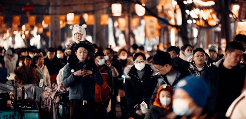 People in Face Masks Walking on a Street