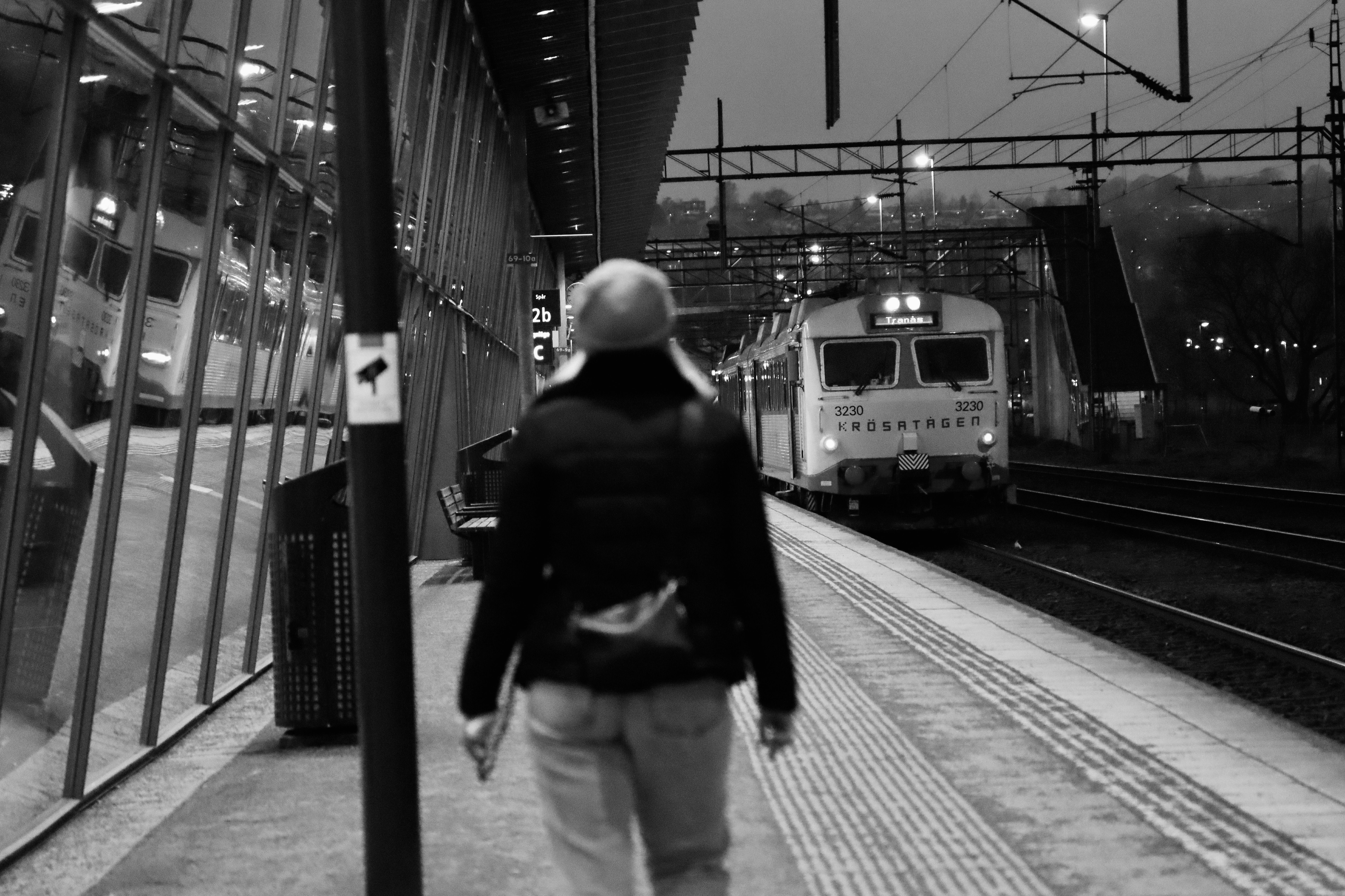 Arriving Train behind Woman Walking on Railway Station in Black and ...