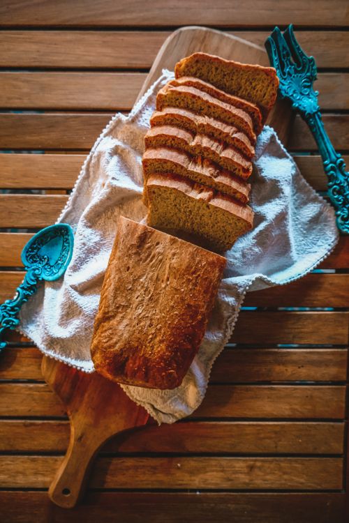 Free Rustic homemade bread slices on a cutting board with vintage cutlery. Stock Photo