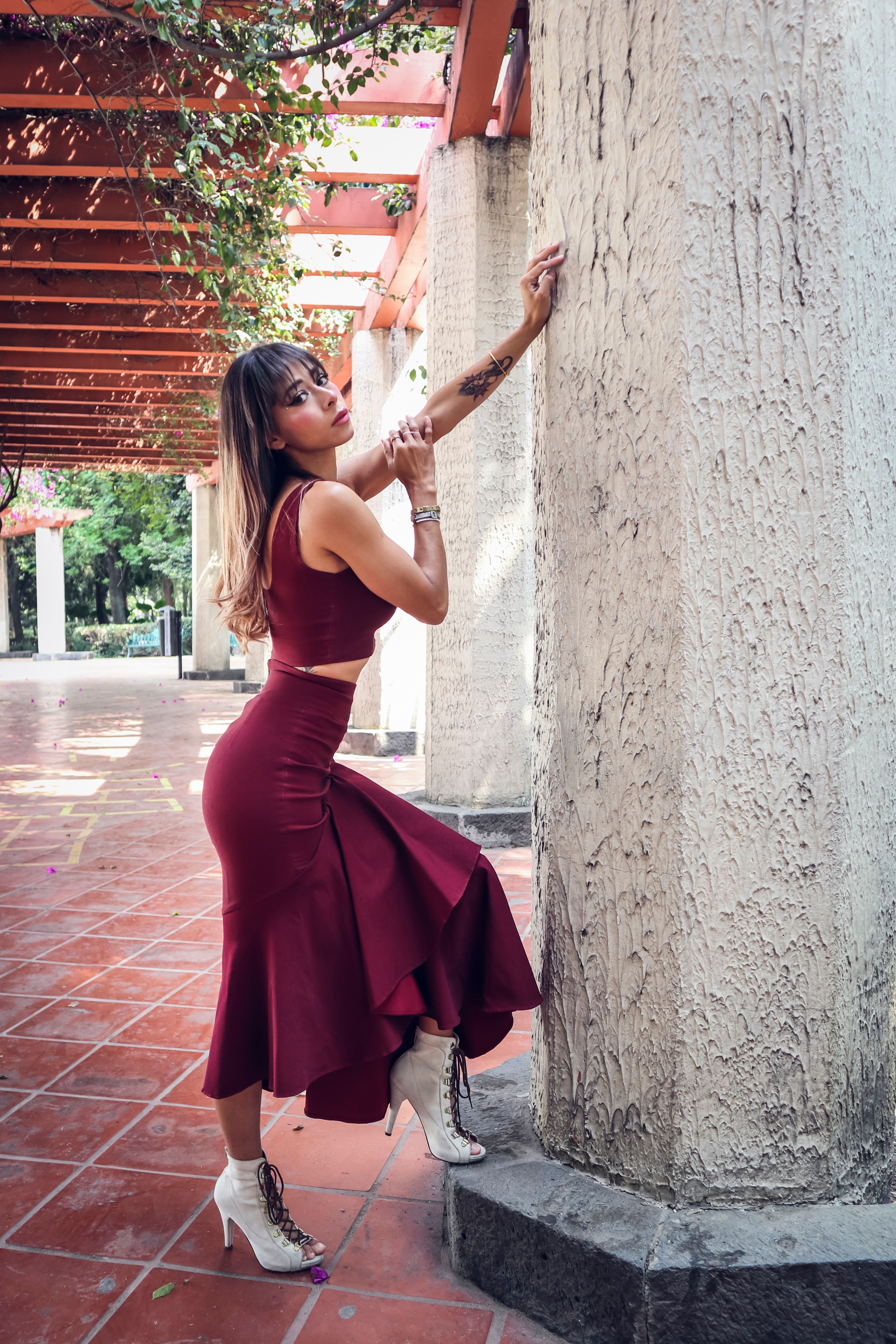 Woman in Red Dress Posing by Wall · Free Stock Photo