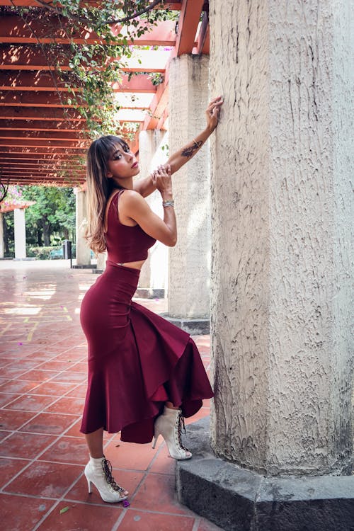 Free Woman in Red Dress Posing by Wall Stock Photo