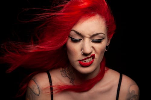 Studio Portrait of a Woman with Red Hair and Tattoos