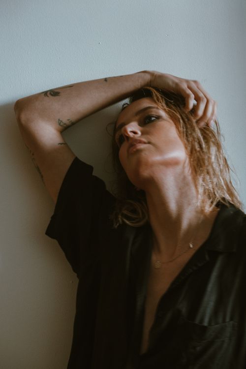 Free Moody portrait of a woman against a wall, capturing an introspective moment. Stock Photo