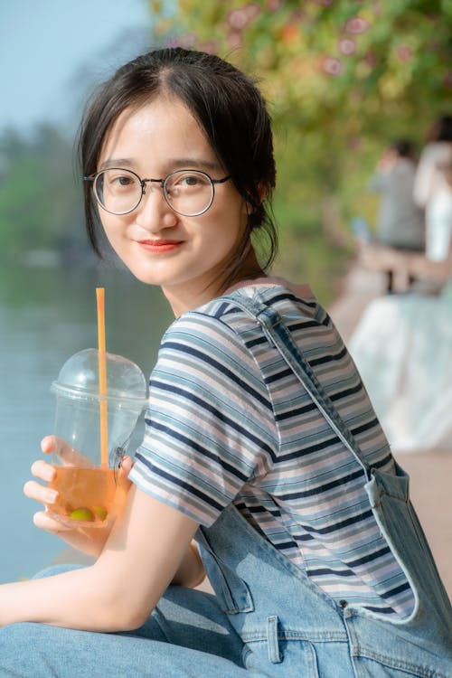 Girl with Drink in Plastic Cup in Park