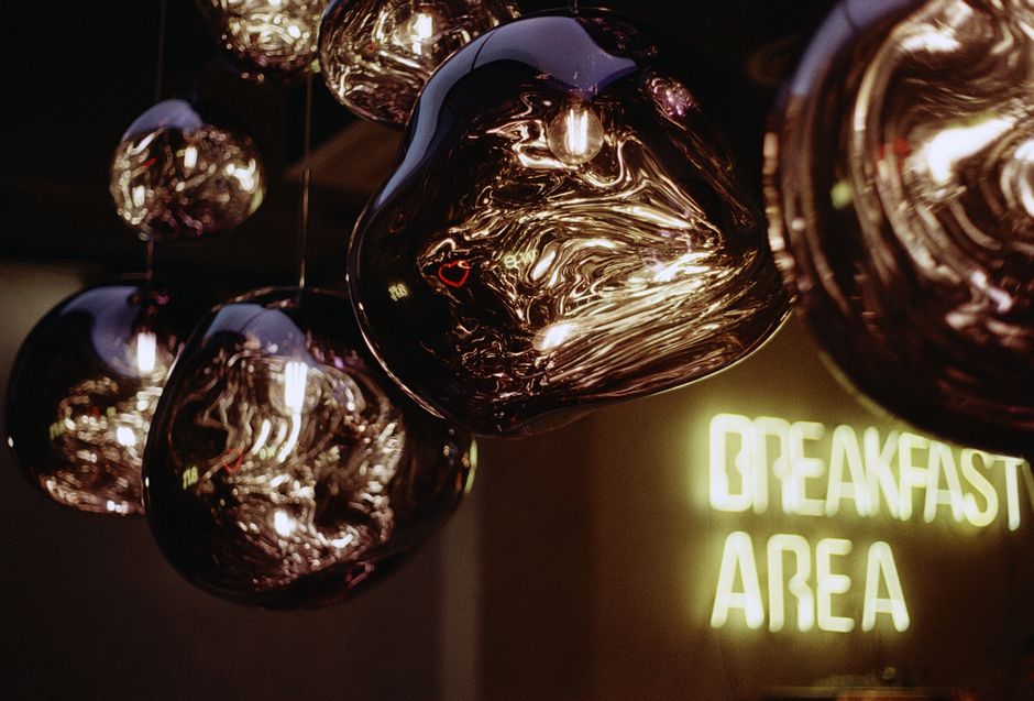 Artistic shot of modern glass ceiling lamps reflecting abstract patterns in a breakfast area.
