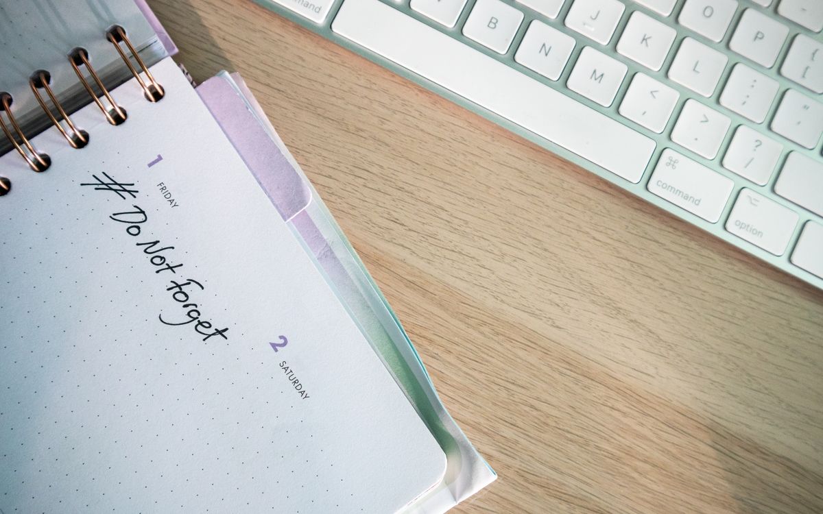 A close-up shot of a planner and keyboard on a desk, showcasing organization.
