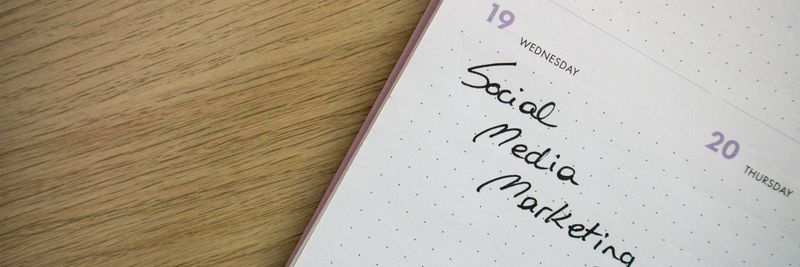 Close-up of a notebook page with 'Social Media Marketing' handwritten on it.