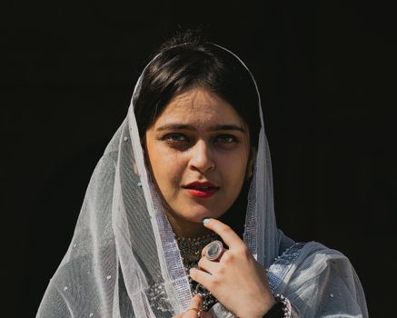 Portrait of a young woman wearing a white veil, showcasing traditional elegance and beauty.