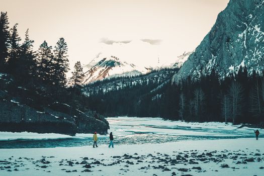 Scenic winter hike along a snowy riverbank in Banff National Park, Alberta, Canada.