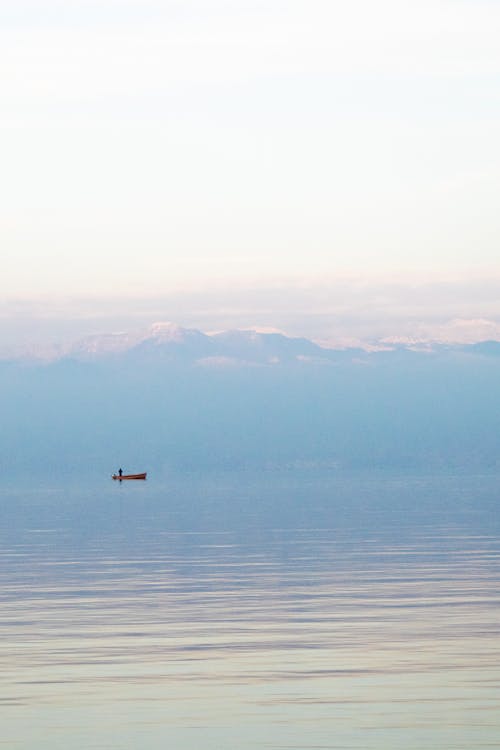 Boat Sailing in Water in Fog at Dawn