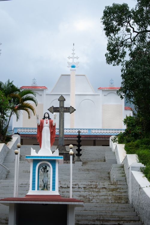 Free View of St. Sebastian's Church with Jesus statue and cross in Munnar, India, showcasing religious architecture. Stock Photo
