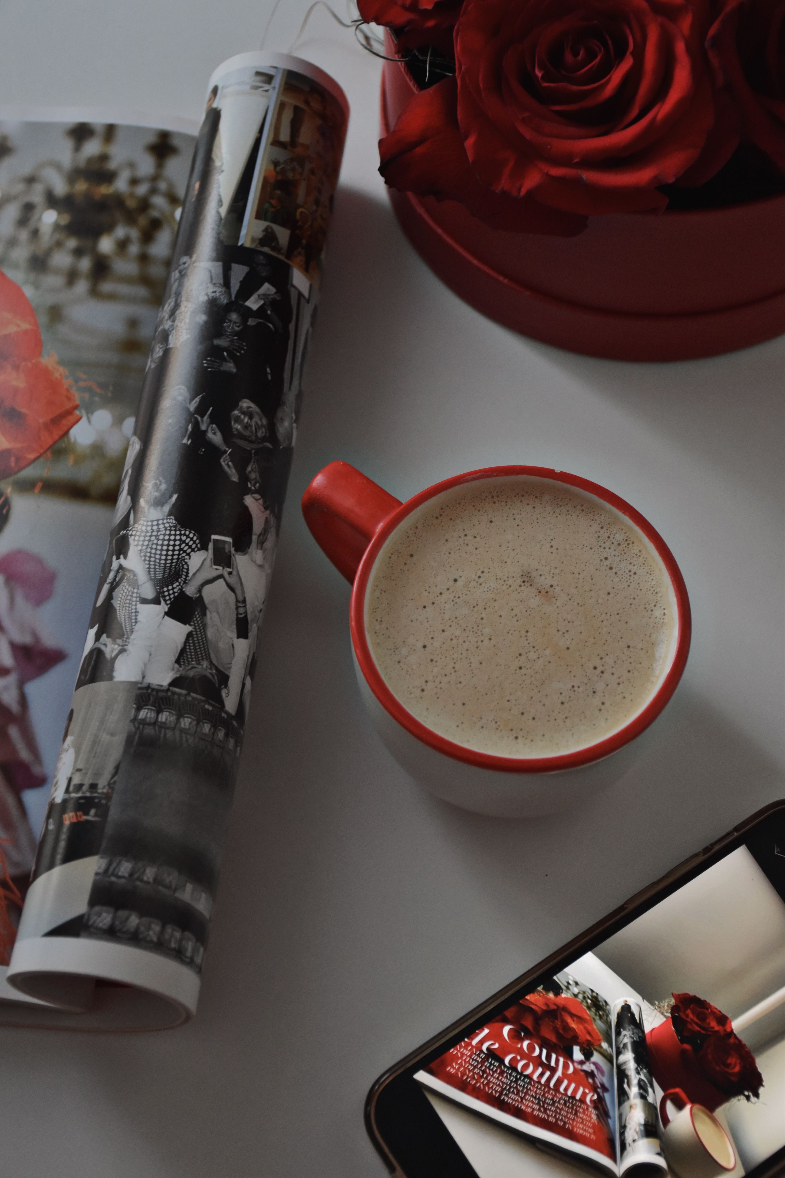 Enjoy a warm cup of coffee with a magazine and red roses in a cozy setting.