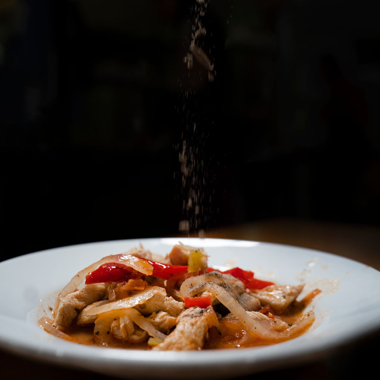 slow cooker chipotle chicken — shredded chicken in smoky red pepper sauce plated with peppers