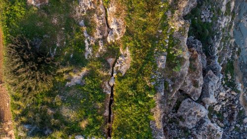 Free Stunning top view of rocky cliffs and greenery in Mellieħa, Malta, showcasing natural beauty. Stock Photo