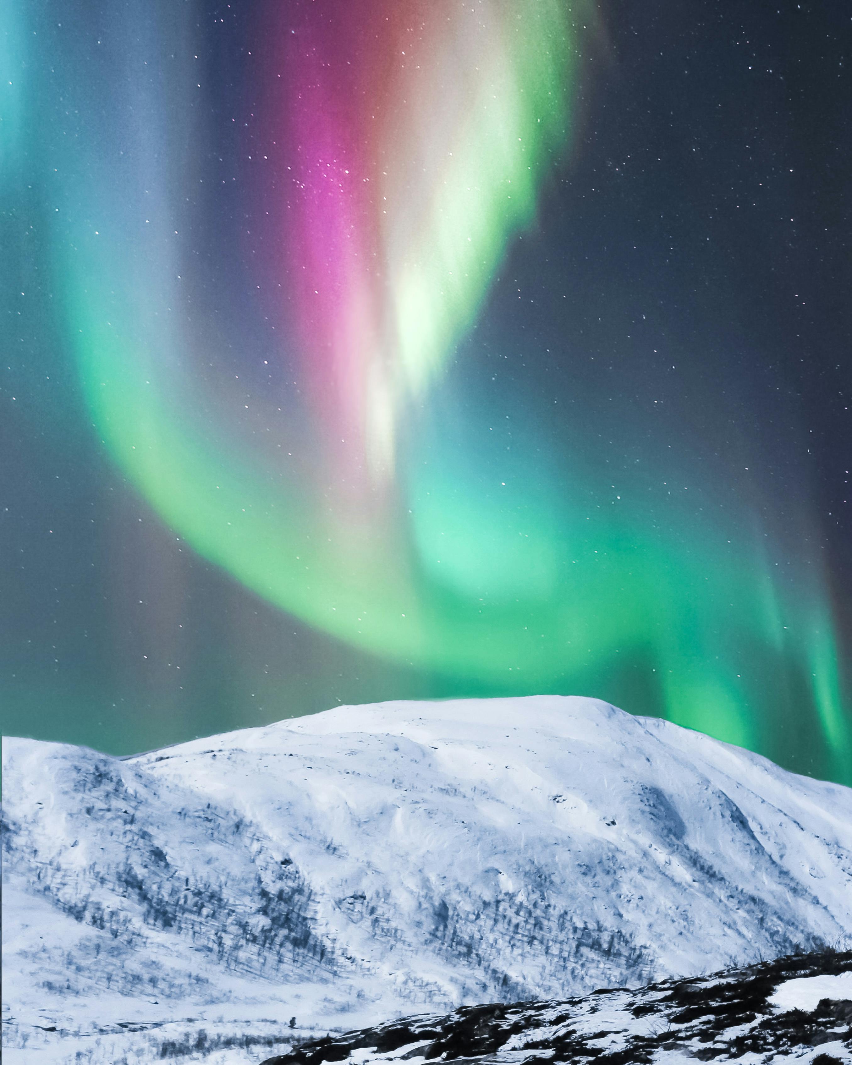 Colorful polar lights over snowy mountain