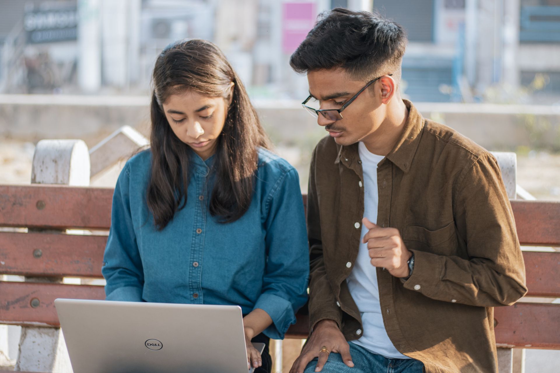 Two students collaborating over a laptop.