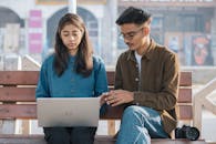 Young Indian Photographer is Helping her friend in the work she is doing on her laptop . The purpose of life is not to be happy. It is to be useful, to be honorable, to be compassionate, t...