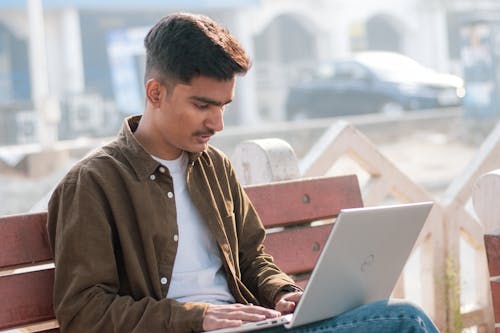 Young indian boy is doing his work in laptop.