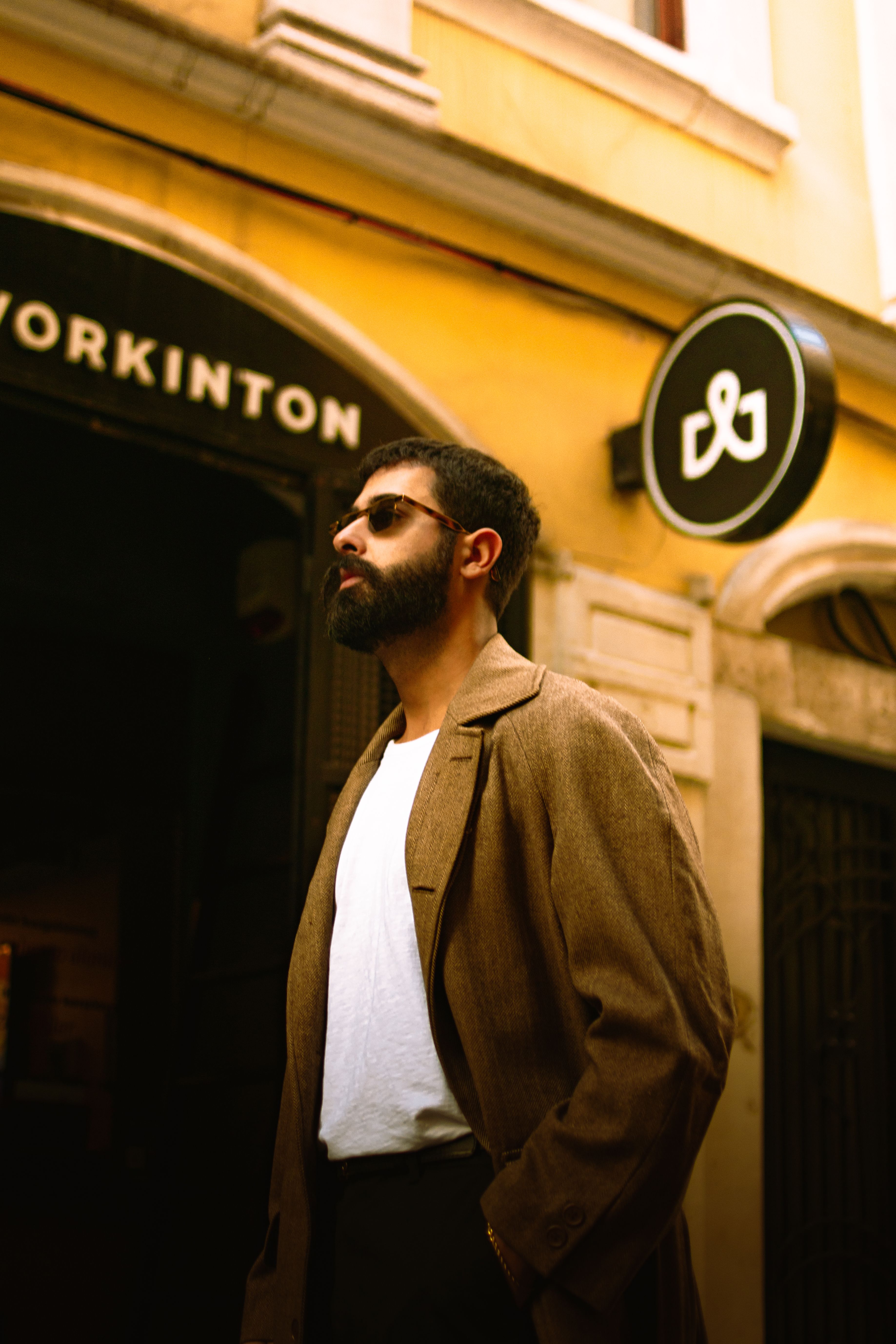 A fashionable man with beard standing outdoors in Istanbul.