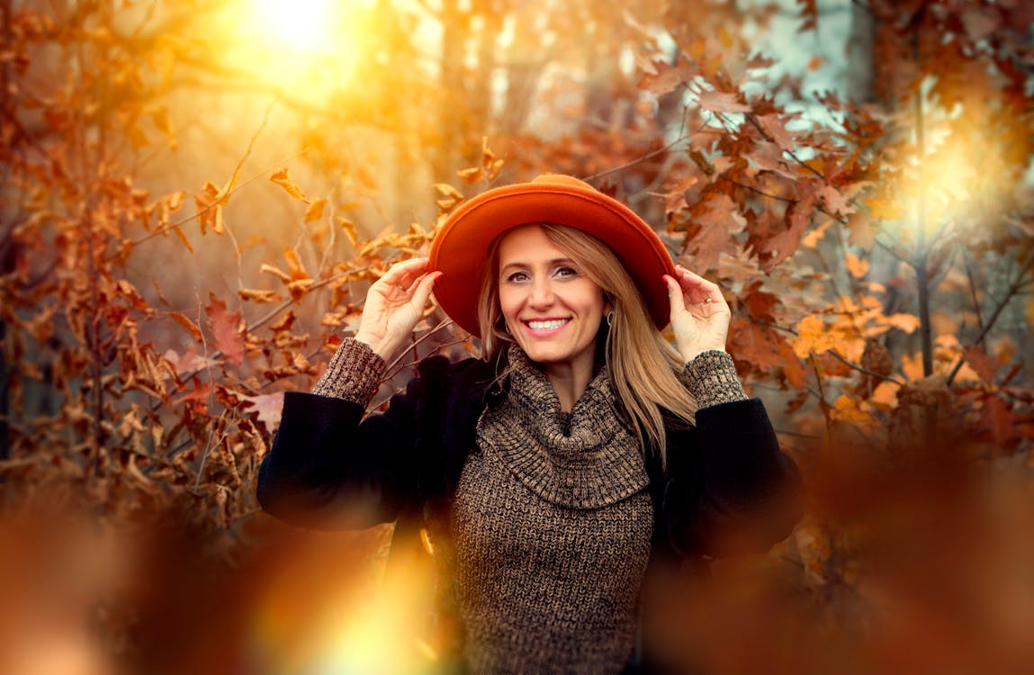 Free Smiling Woman Holding Orange Sun Hat  Stock Photo