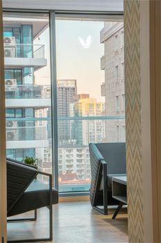 Bright urban scene through a large window from a stylish living room.