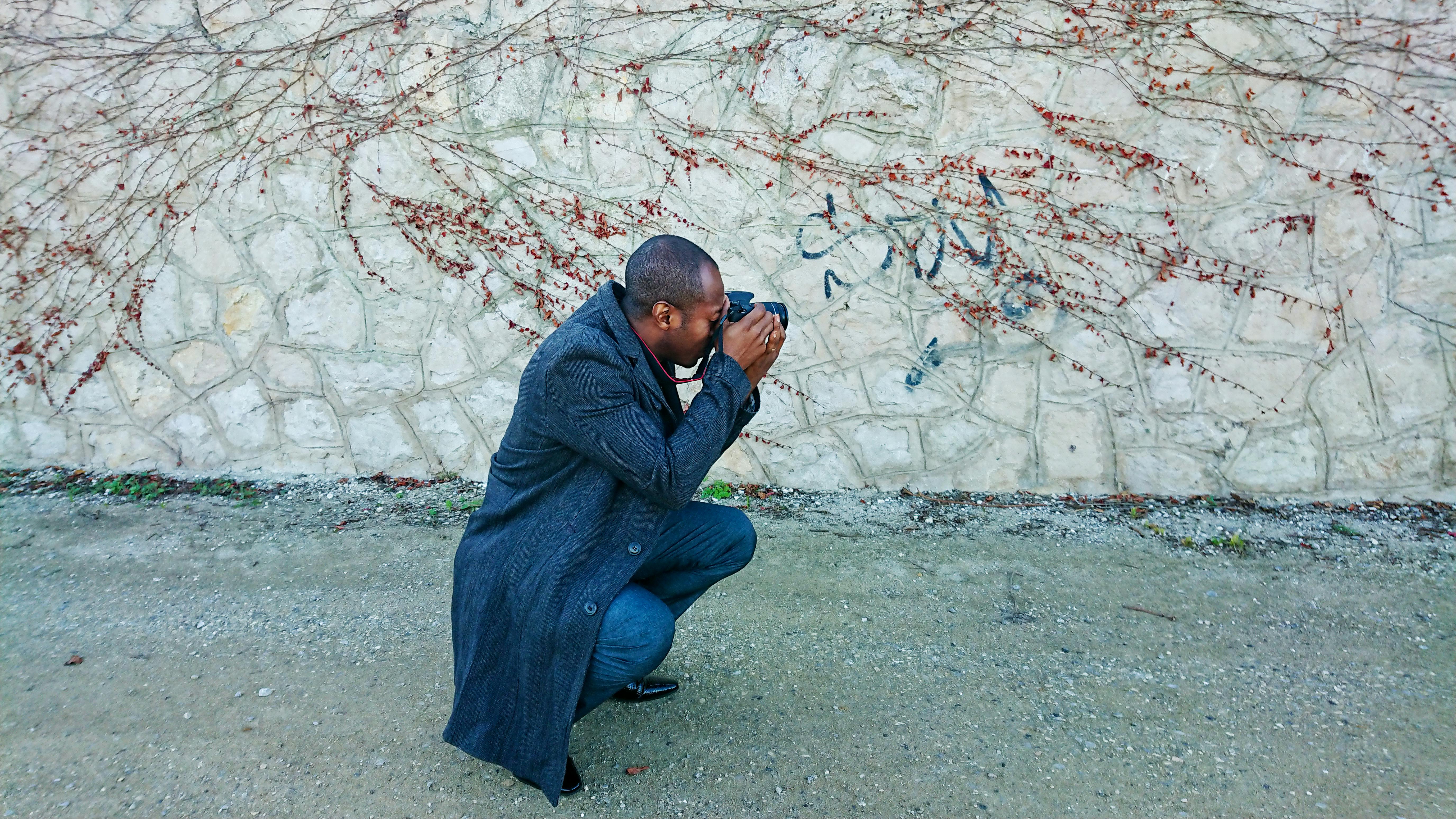 photographer crouching on the street and taking a photo