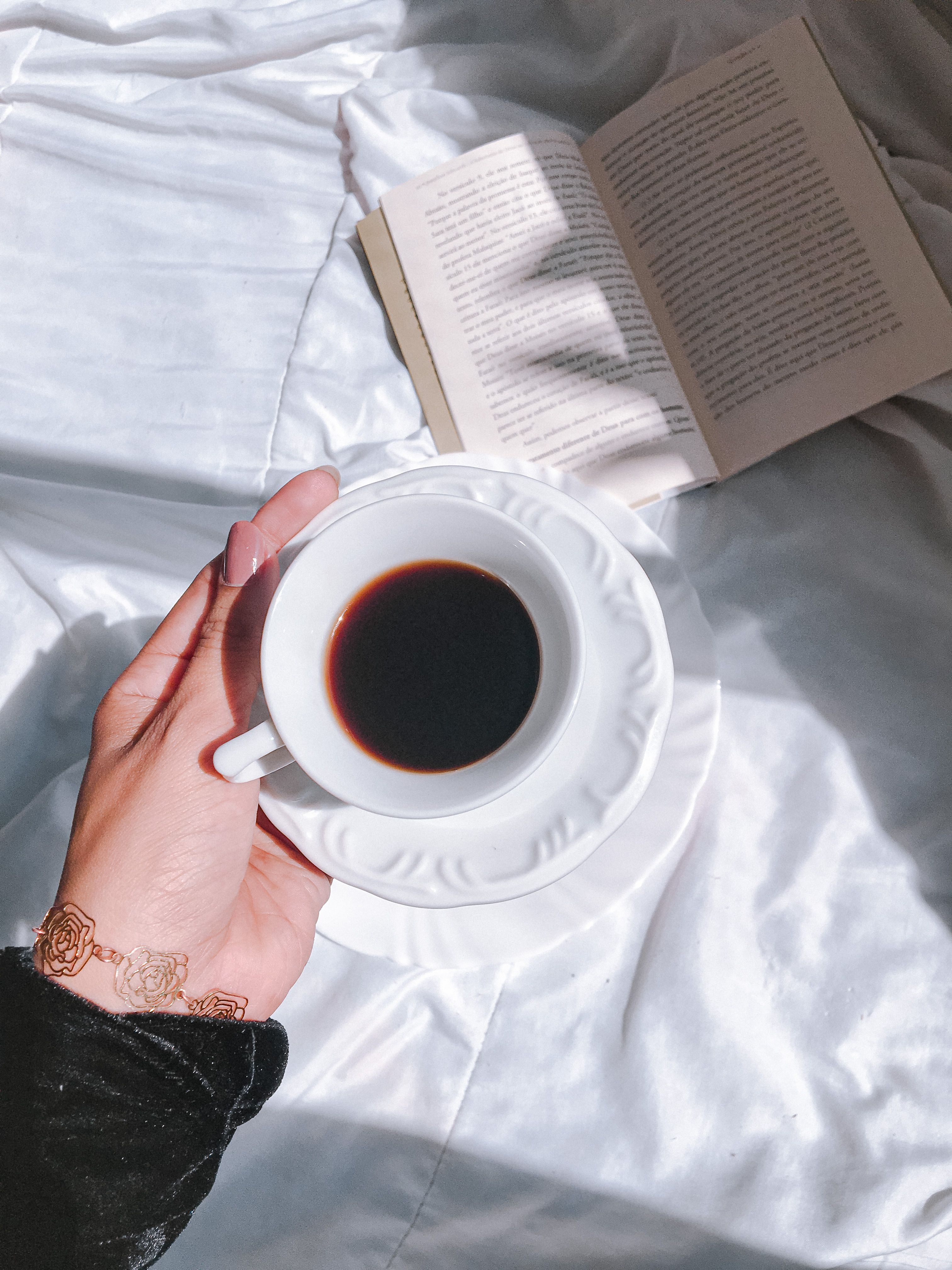 A serene morning scene with a cup of coffee held over an open book, embracing leisure.