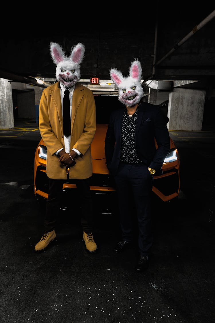 Men In Creepy Rabbit Masks Standing In Front Of A Car 