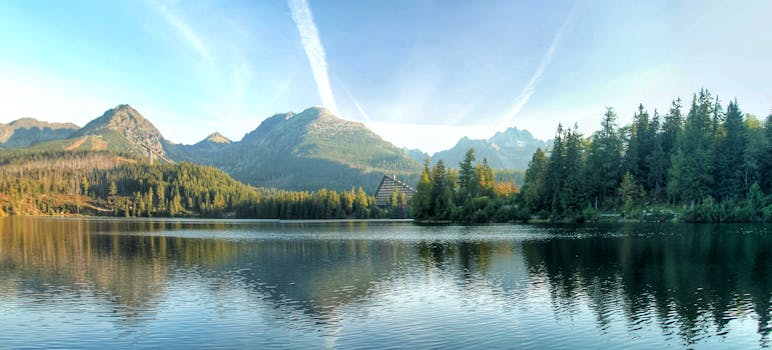 Explore the tranquil mountain landscape of Vysoké Tatry with serene lake reflections and lush forests.