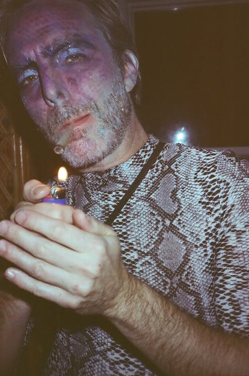 Man in a Costume Lighting up a Cigarette 