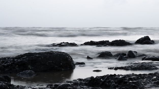 A black and white photo of rocks and water