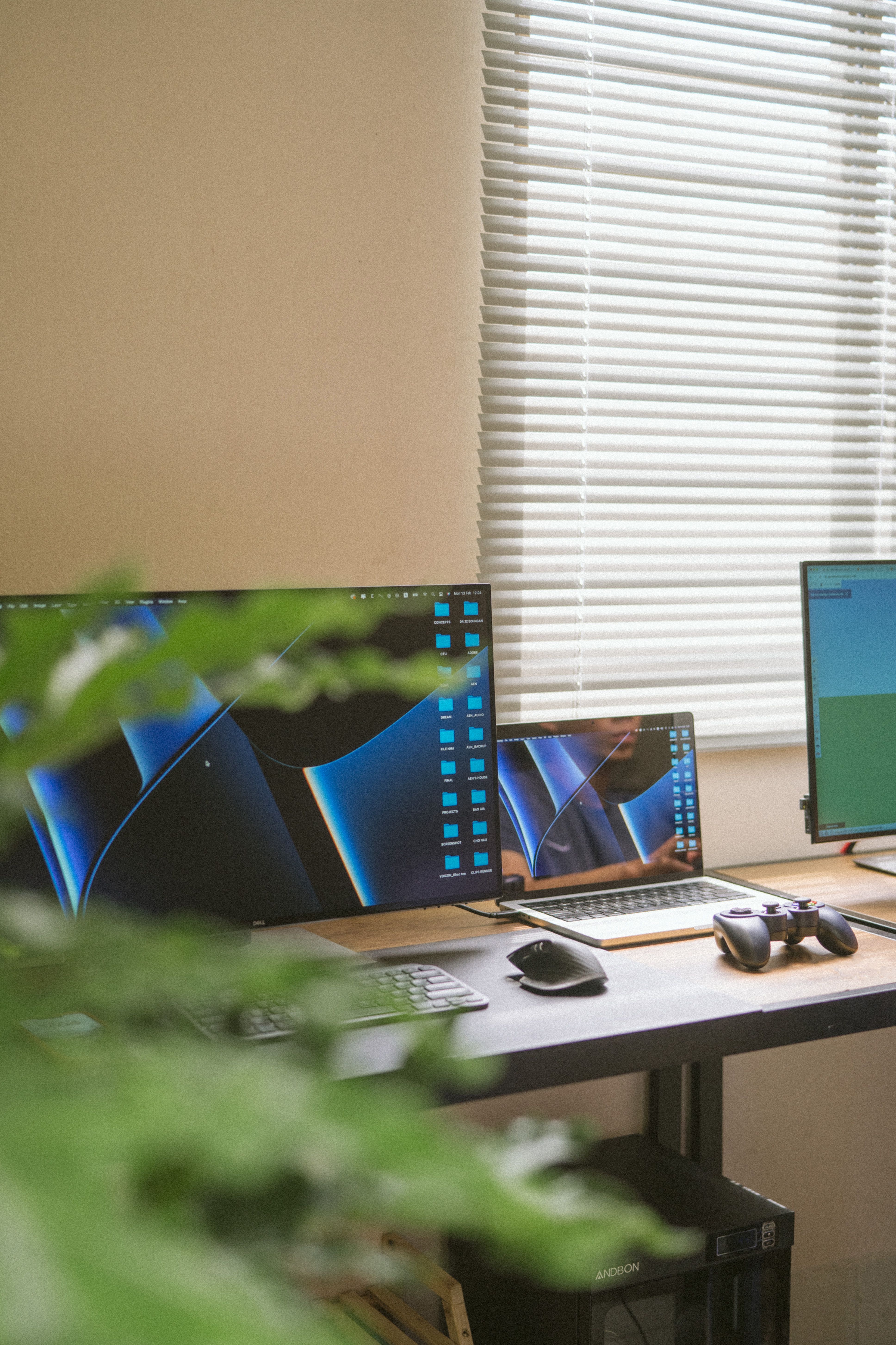 A tidy office desk setup featuring a laptop, monitors, and peripherals in a well-lit room.