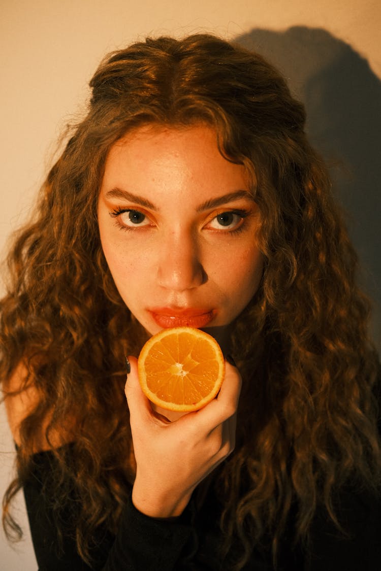 Young Woman Holding An Orange 