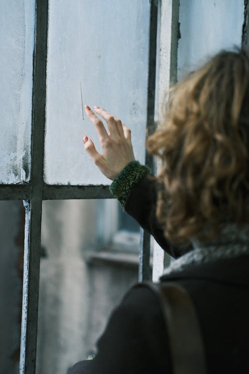 Woman Touching an Old Glass Window
