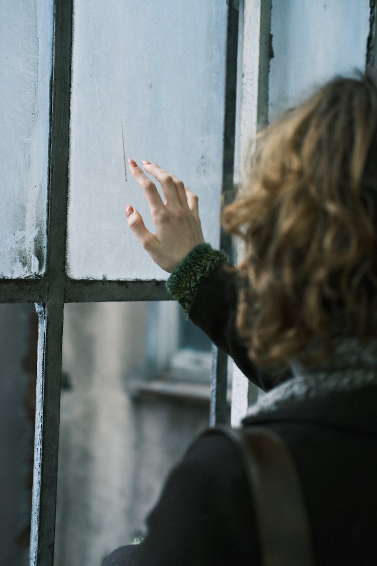 Woman Touching An Old Glass Window