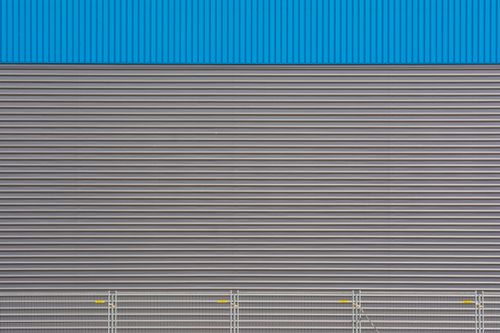 Free Textured metal wall with blue top section, featuring horizontal stripes and industrial design. Stock Photo