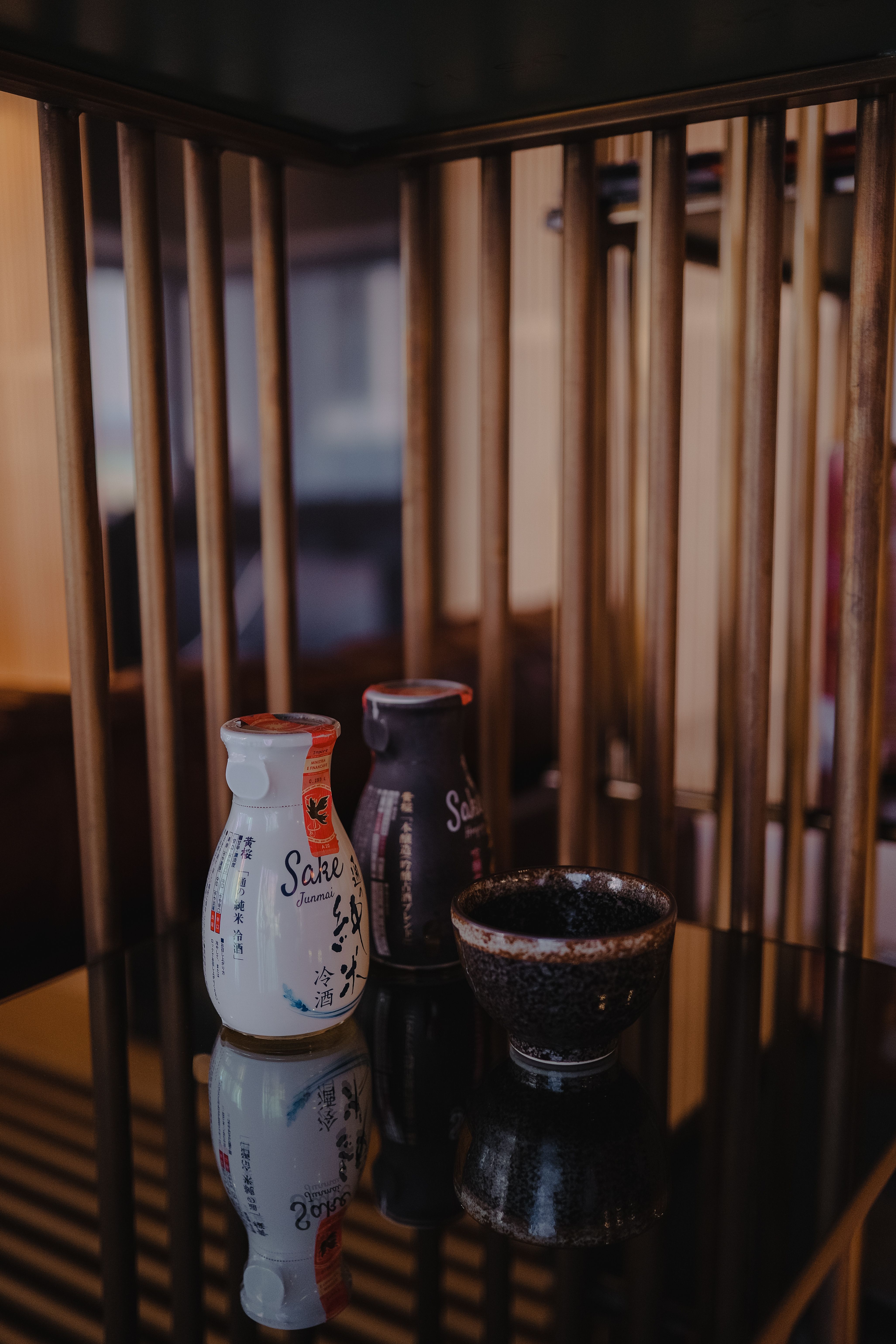 Bottles of Sake with a Bowl on a Table, and a Wooden Construction ...