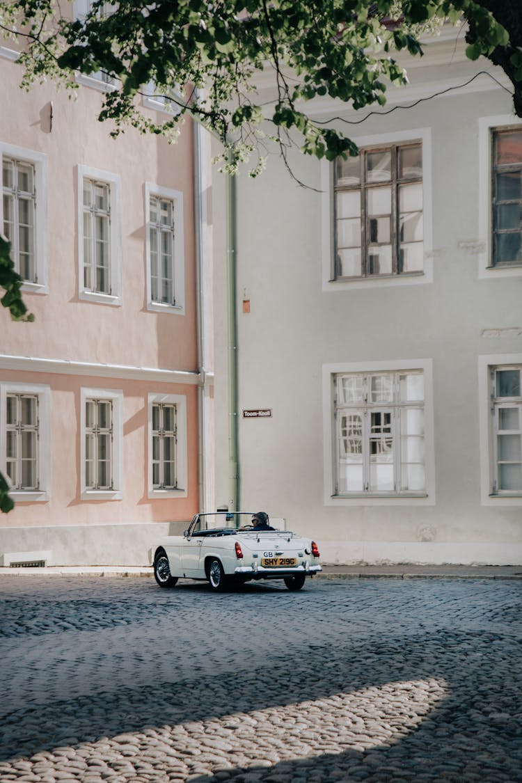 White Vintage Convertible Car On A City Street