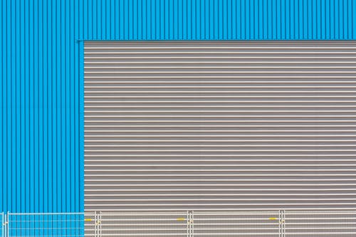Facade of a Blue Building with Roller Doors 