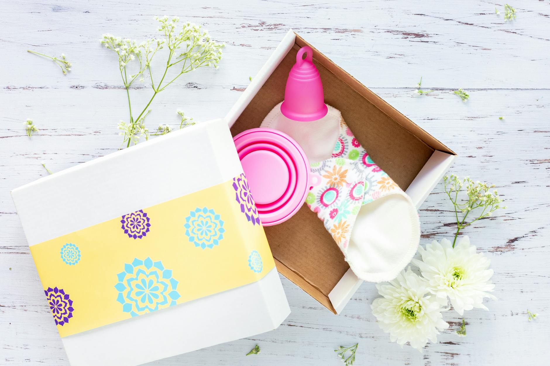 a menstrual cup and sanitary napkin in a box
