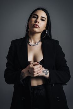 Portrait of a stylish woman in an elegant blazer with confident expression captured in a studio setting.