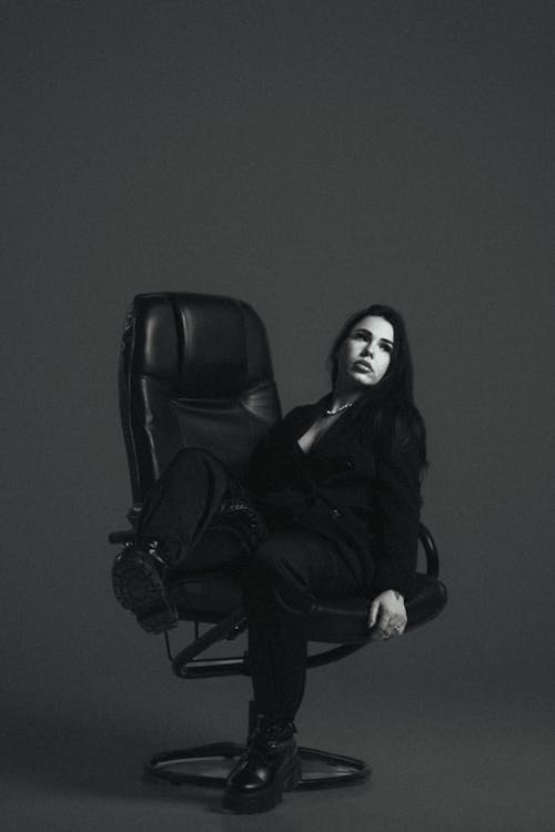 Woman in Suit Sitting on a Revolving Chair 