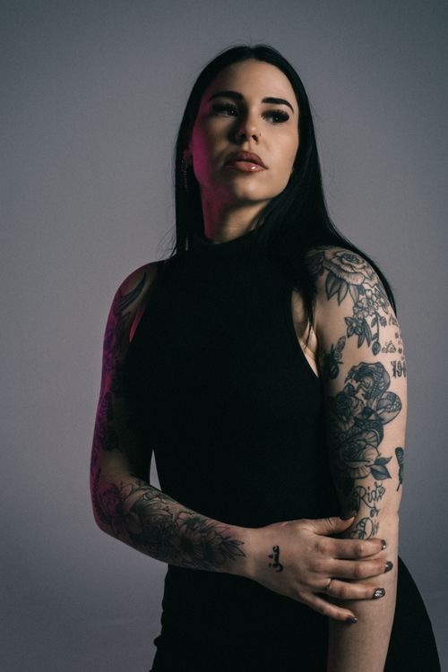 Free Studio portrait of a tattooed woman posing with a contemplative expression. Stock Photo