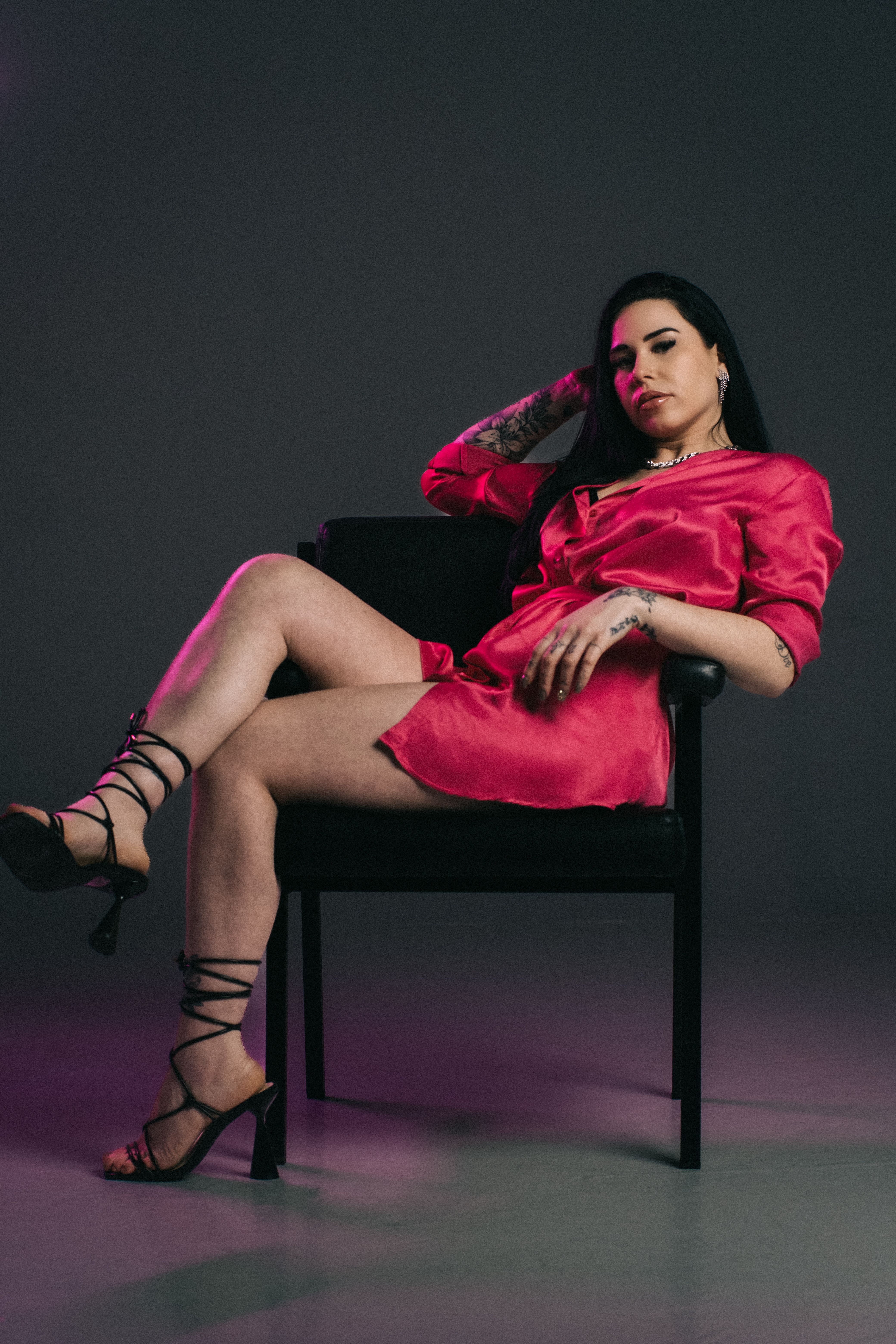 A woman in a pink dress sitting on a chair · Free Stock Photo