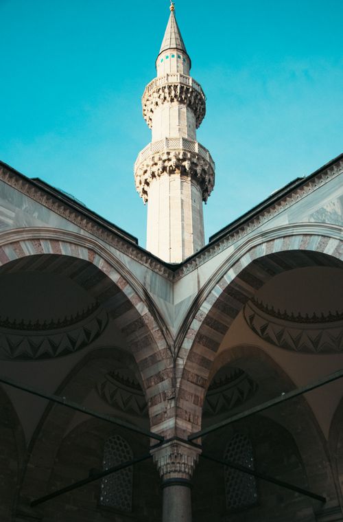 Free Captivating low angle view of a mosque minaret with blue sky backdrop, showcasing Islamic architecture. Stock Photo