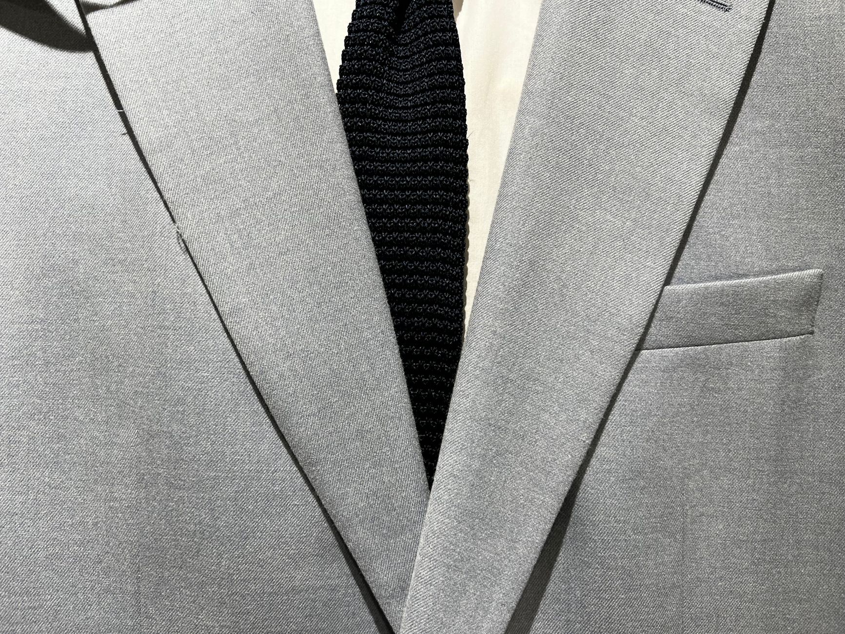 A perfectly tailored navy suit on a wooden hanger