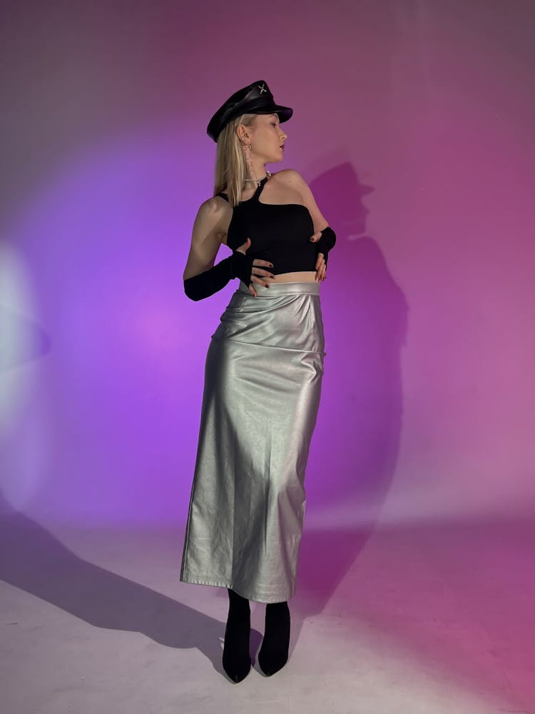 Female Model Wearing An Uniform Cap, A Crop Top And A Long Silver Colored Skirt