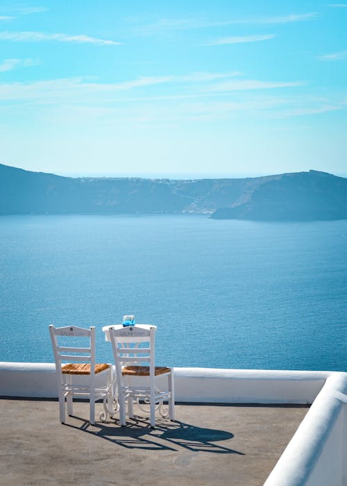 Chairs on a Terrace Overlooking Sea and Distant Mountains