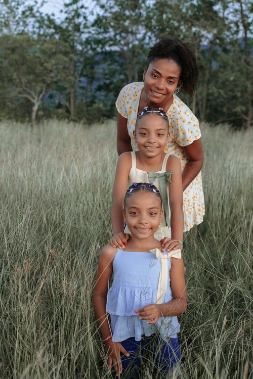 Free Mother and daughters enjoying a scenic day outdoors, smiling in a natural setting. Stock Photo