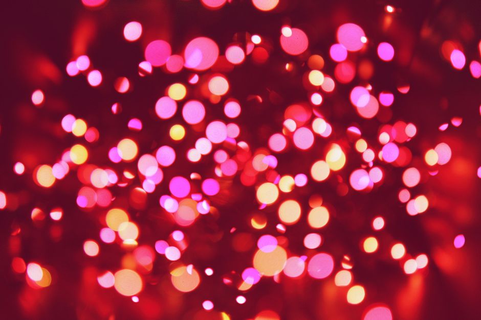 Colorful bokeh image featuring bright pink and orange lights creating a festive atmosphere.